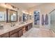 Well-lit main bathroom with double sinks, framed mirrors, and a separate walk-in shower at 1564 Fieldbrook St, Henderson, NV 89052