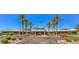 Beautiful exterior of community clubhouse with flags, palm trees, and well-manicured landscaping at 2110 King Mesa Dr, Henderson, NV 89012
