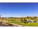 View of a golf course with green grass, sand traps, a small lake with a fountain, trees, and mountains in the distance at 2110 King Mesa Dr, Henderson, NV 89012