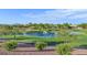 Photo of a green golf course with a lake and fountain, trees, and a distant mountain range on a partly cloudy day at 2110 King Mesa Dr, Henderson, NV 89012