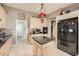 Well-lit kitchen featuring an island, tile floors, stainless steel refrigerator, and stylish countertops at 2110 King Mesa Dr, Henderson, NV 89012