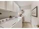 Laundry room with neutral paint, white cabinets, tile floors, and a white Whirlpool washer and dryer at 2110 King Mesa Dr, Henderson, NV 89012