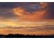 Beautiful sunset with orange-pink hues, with silhouetted trees and buildings in the foreground and the Stratosphere in the distance at 2110 King Mesa Dr, Henderson, NV 89012