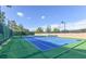 Outdoor tennis court with blue surface, green borders, surrounding fence, and net under a clear sky at 2110 King Mesa Dr, Henderson, NV 89012
