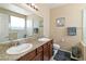 This bathroom offers double sinks with granite countertops and a framed mirror at 2128 Delmar Farms Ct, Laughlin, NV 89029