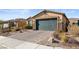 Charming single-story home featuring a two-car garage, stone accents, and desert landscaping at 2128 Delmar Farms Ct, Laughlin, NV 89029