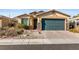 Charming single-story home featuring a two-car garage, stone accents, and desert landscaping at 2128 Delmar Farms Ct, Laughlin, NV 89029