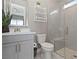 Modern bathroom with a glass-enclosed shower, gray vanity, and decorative plant enhancing the space's appeal at 2153 King Crest Ct, Henderson, NV 89052