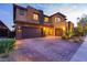 Beautiful home showcasing a three-car garage, brick driveway, and desert landscaping at 2153 King Crest Ct, Henderson, NV 89052