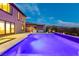 Illuminated pool at dusk with outdoor kitchen and seating at 2153 King Crest Ct, Henderson, NV 89052