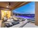 Covered patio area boasts an outdoor kitchen and seating area overlooking a modern pool with beautiful mountain views at 2153 King Crest Ct, Henderson, NV 89052