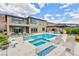 Resort style pool with attached spa, sun loungers, outdoor kitchen, and fire feature in this attractive backyard at 2153 King Crest Ct, Henderson, NV 89052