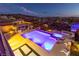 Inviting pool and spa with an outdoor kitchen, set against a picturesque mountain and city backdrop at twilight at 2153 King Crest Ct, Henderson, NV 89052