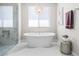Luxurious bathroom features a soaking tub with chandelier, a walk-in shower, and neutral decor at 220 Villa Borghese St, Las Vegas, NV 89138
