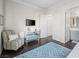 Stylish bedroom with a comfortable chair, sleek TV stand, and dark hardwood floors at 220 Villa Borghese St, Las Vegas, NV 89138
