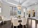 Well-lit dining room featuring a modern chandelier, large window, and a cozy seating arrangement at 220 Villa Borghese St, Las Vegas, NV 89138