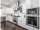 Gourmet kitchen features stainless steel appliances, white cabinetry, marble countertops, and a tile backsplash at 220 Villa Borghese St, Las Vegas, NV 89138