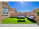 Backyard features lush artificial turf, lounge seating, and a charming patio table set at 242 Polaris Ridge Ave, Henderson, NV 89011
