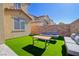 Backyard with artificial turf, patio furniture and desert landscaping beyond the block wall at 242 Polaris Ridge Ave, Henderson, NV 89011