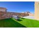 Open backyard with artificial turf, patio furniture, and a brick privacy wall at 242 Polaris Ridge Ave, Henderson, NV 89011