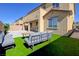 Spacious backyard with artificial grass, stone pavers, patio furniture, and building exterior at 242 Polaris Ridge Ave, Henderson, NV 89011