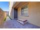 Cozy backyard area with stone pavers, adjacent turf and a textured exterior wall at 242 Polaris Ridge Ave, Henderson, NV 89011