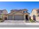Charming two-story home with a three-car garage and solar panels under a clear blue sky at 242 Polaris Ridge Ave, Henderson, NV 89011