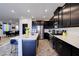 Chic kitchen with black cabinetry, white countertops, and stainless steel appliances, seamlessly connecting to the dining area at 242 Polaris Ridge Ave, Henderson, NV 89011