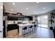 A spacious kitchen with black cabinets, stainless steel appliances, and an island with bar stool seating at 242 Polaris Ridge Ave, Henderson, NV 89011