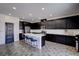 Stylish kitchen with black cabinets, stainless steel appliances, and a large island at 242 Polaris Ridge Ave, Henderson, NV 89011