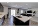 Modern kitchen featuring island that looks out to living room and backyard sliding glass door at 242 Polaris Ridge Ave, Henderson, NV 89011