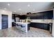 Modern kitchen boasting sleek black cabinetry, a central island, and stainless steel appliances for a stylish cooking experience at 242 Polaris Ridge Ave, Henderson, NV 89011