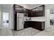 Modern kitchenette features stainless steel refrigerator, dark cabinets and white countertops at 242 Polaris Ridge Ave, Henderson, NV 89011