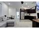 Open-concept living area with gray sofa, dining table, kitchen with stainless steel appliances, and bright lighting at 242 Polaris Ridge Ave, Henderson, NV 89011