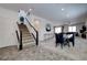 Stylish living room featuring a staircase, modern dining area, and neutral color palette at 242 Polaris Ridge Ave, Henderson, NV 89011