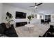 Spacious living room featuring stylish sofas, sleek media console, and modern dining area at 242 Polaris Ridge Ave, Henderson, NV 89011