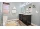 Bright bathroom features double vanity with granite countertops, wood-look flooring, and spa towels at 2421 Sunrise Springs Ct, North Las Vegas, NV 89031