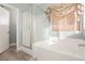 Bright bathroom features a shower, bathtub, and window with a bamboo blind at 2421 Sunrise Springs Ct, North Las Vegas, NV 89031