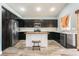 Modern kitchen with dark wood cabinets, stainless steel appliances, island and stylish wood-look tile flooring at 2421 Sunrise Springs Ct, North Las Vegas, NV 89031