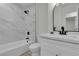 Modern bathroom featuring a tub with marble tile, white vanity and an oval mirror at 2461 Old Forge Ln # 103, Las Vegas, NV 89121