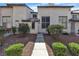 A townhome with well-maintained landscaping and a sidewalk leading to the front door at 2461 Old Forge Ln # 103, Las Vegas, NV 89121