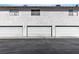 Exterior view of garages with white doors set against a light-colored stucco wall at 2461 Old Forge Ln # 103, Las Vegas, NV 89121