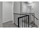 Carpeted stairway with a black metal banister at 2461 Old Forge Ln # 103, Las Vegas, NV 89121