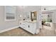 Bright bathroom with double sinks, decorative mirror, wood-style tile flooring, and a view to the backyard at 2654 Summit Springs St, Henderson, NV 89044
