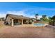 The backyard includes a pool with an attached spa, a covered patio, and desert landscaping at 2939 Crown Bluffs Ct, Las Vegas, NV 89117