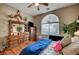 Bedroom showcasing hardwood floors, ceiling fan, an arch window and classic wood dresser at 2939 Crown Bluffs Ct, Las Vegas, NV 89117