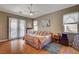 Comfortable bedroom with neutral walls, light wood flooring, fan and access to the backyard through glass doors at 2939 Crown Bluffs Ct, Las Vegas, NV 89117