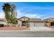 The exterior showcases a well-maintained three-car garage and desert landscaping in front of this single-story home at 2939 Crown Bluffs Ct, Las Vegas, NV 89117