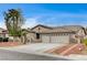 Well-maintained home with a three-car garage, tile roof, desert landscaping, and a welcoming entrance at 2939 Crown Bluffs Ct, Las Vegas, NV 89117