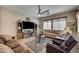Well-lit living room showcasing comfortable seating, tile floors, a large TV, and a cozy atmosphere at 2939 Crown Bluffs Ct, Las Vegas, NV 89117
